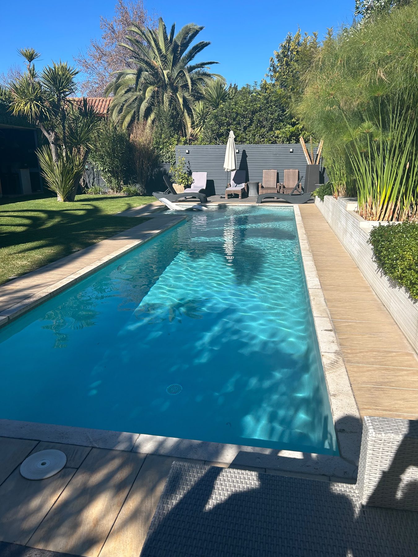 Piscina residencial terminada por Freshpool Chile, con agua cristalina, deck y jardín